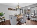 Well-lit dining area with a hardwood floor and a rustic wood table surrounded by upholstered chairs at 3135 Nectar Dr, Powder Springs, GA 30127