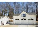 Detached three-car garage with white doors and a matching adjacent outbuilding at 5322 Seaton Dr, Dunwoody, GA 30338