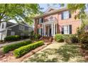 Brick home with a columned porch, well-maintained landscaping, and mature trees at 3448 Paces Ferry Cir, Smyrna, GA 30080