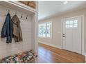 Cozy entryway with a built-in bench and coat rack, hardwood floors, and a white front door at 442 Mountain Park Trl, Stone Mountain, GA 30087