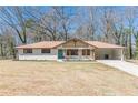 Inviting single-story home with white brick, covered parking and a well-manicured front yard at 442 Mountain Park Trl, Stone Mountain, GA 30087