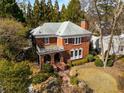 An aerial view of a two-story brick house surrounded by lush greenery and mature trees at 1272 Oakdale Ne Rd, Atlanta, GA 30307
