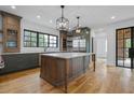 Gourmet kitchen featuring a large central island, custom cabinets, stainless appliances, and hardwood flooring at 239 E Wesley Ne Rd, Atlanta, GA 30305