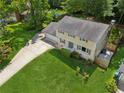 An aerial view of a well-maintained two-story home, green lawn, and long driveway with a neighboring pool at 1231 Sanden Ferry Dr, Decatur, GA 30033