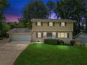 Charming two-story home with a well-manicured lawn, attached garage, and neutral color palette under a twilight sky at 1231 Sanden Ferry Dr, Decatur, GA 30033