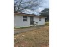 A quaint single story home shows a side entrance and narrow walkway with simple landscaping at 136 Tye St, Stockbridge, GA 30281