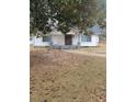 A cute, single-story home is framed by a large tree and walkway and freshly painted exterior at 136 Tye St, Stockbridge, GA 30281