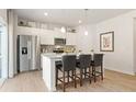 Bright kitchen with stainless steel appliances, a center island with seating, and white cabinetry at 8518 Polston Place Lot 131, Douglasville, GA 30134