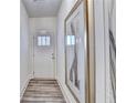 Hallway featuring a white front door, wood floor, and framed artwork at 2702 Ne Almand Lane, Conyers, GA 30013