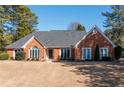 Beautiful single-story brick home featuring a well-maintained lawn and mature trees at 330 Todwick Dr, Roswell, GA 30075