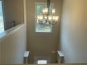 Bright foyer featuring a modern chandelier, natural light, and neutral wall paint at 3624 Peeksville Rd, Locust Grove, GA 30248