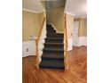 Carpeted stairs with hardwood floors and decorative trim details at 9936 Point Vw, Jonesboro, GA 30238