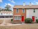 Charming townhome with a red front door, brick facade, tidy landscaping, and a welcoming feel at 407 Paper Mill Lndg, Roswell, GA 30076