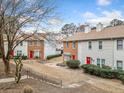 Townhomes with brick and siding exteriors, red front doors, and well-maintained landscaping at 407 Paper Mill Lndg, Roswell, GA 30076