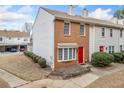 Townhome with a red front door, brick facade, neat landscaping, and a welcoming curb appeal at 407 Paper Mill Lndg, Roswell, GA 30076