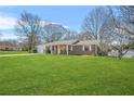 Traditional-style brick home boasts a well-kept lawn, an attached garage, and a welcoming covered front porch entry at 897 Marie Lane Sw Ln, Conyers, GA 30094