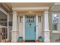 Close-up of a stylish light blue front door with decorative hardware and brick accents at 15 Northwood Ne Ave, Atlanta, GA 30309