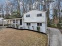 A view of the house showing the landscaping and concrete driveway with a view of the side of the house at 847 Magna Carta Nw Dr, Atlanta, GA 30318