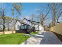 Modern renovated home with black and white trim, outdoor deck, and a concrete driveway at 3482 Atlanta St, Atlanta, GA 30337
