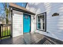Home's front door boasts a vibrant turquoise hue, complemented by a black trim and white siding at 3482 Atlanta St, Atlanta, GA 30337
