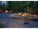 Relaxing backyard with a stone fire pit, red Adirondack chairs, a waterfall and lush landscaping at 15 Winterville Dr, Rockmart, GA 30153