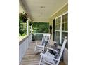 Inviting covered porch with rocking chairs, decorative pillows, and hanging plants, perfect for relaxation at 15 Winterville Dr, Rockmart, GA 30153