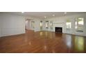 Spacious living room with gleaming hardwood floors, a fireplace, and multiple windows with natural light at 671 Benson Hurst Sw Dr, Mableton, GA 30126
