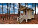 A cute outbuilding with porch and stairs is nestled among trees on property at 1049 Fieldstone Dr, Canton, GA 30114