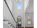 Elegant foyer featuring a high ceiling, a window and staircase with dark wood trim at 2620 Milford Ln, Alpharetta, GA 30009