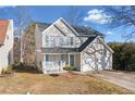 Charming two-story home showcasing blue shutters, a two-car garage, and a well-manicured front yard at 826 Shore Dr, Lithonia, GA 30058