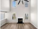 Bright living room with a soaring ceiling, modern ceiling fan, fireplace, and beautiful flooring at 826 Shore Dr, Lithonia, GA 30058