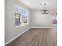 Bright living room featuring light gray walls, contemporary light fixture, and large windows overlooking the outdoors at 826 Shore Dr, Lithonia, GA 30058