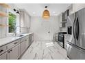 Modern kitchen featuring stainless steel appliances, custom cabinets, stylish flooring, and a kitchen island at 1015 Michigan Nw Ave, Atlanta, GA 30314