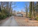 Inviting two-story home with a long driveway surrounded by mature trees and natural landscaping at 5664 Colton Dr, Atlanta, GA 30342