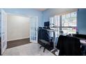 Well-lit office space featuring hardwood floors, light blue walls, and a large window with white blinds at 6101 Providence Way, Union City, GA 30291