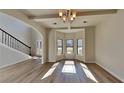 Sunlit open floorplan living room featuring new flooring, large windows, and view to foyer staircase at 8103 White Oak Loop, Stone Mountain, GA 30038