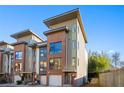 Modern multi-story townhome featuring a brick facade, large windows, and attached garage at 975 Moda Drive Dr, Atlanta, GA 30316