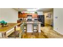 Open kitchen featuring an island with seating, wood cabinets, modern appliances, and tile floors at 1155 Magnolia Gardens Walk, Mcdonough, GA 30253