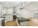 Modern kitchen with white cabinets, black countertops, stainless steel appliances, and a central island at 3469 Sexton Woods Dr, Atlanta, GA 30341