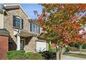 Beautiful brick townhome featuring a covered entryway, one-car garage, and attractive landscaping at 3117 Haynes Park Dr, Lithonia, GA 30038