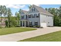 Stylish home with a long driveway, and an attached two-car garage surrounded by a lush green lawn at 8050 Tristan Way, Whitesburg, GA 30185