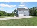 Side view of a well-maintained home with an attached two-car garage and a long, paved driveway at 8050 Tristan Way, Whitesburg, GA 30185