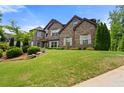 Beautiful two-story brick home with well-manicured lawn and mature trees at 2196 Abbott Dr, Buford, GA 30519
