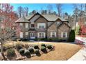 Beautiful brick home showcasing architectural details and a well-maintained lawn in a serene setting at 2196 Abbott Dr, Buford, GA 30519