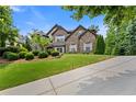 Stunning two-story brick home featuring lush landscaping and a long driveway at 2196 Abbott Dr, Buford, GA 30519