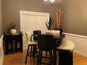 Stylish dining area with dark table and seating, complemented by natural light and modern decor at 1162 Mason Lee, Loganville, GA 30052