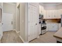 Well-lit kitchen showcasing stainless steel appliances, white cabinetry, and convenient access to the front door at 1910 Cedar Glenn Way # 4401, Atlanta, GA 30339