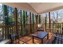 Relaxing covered porch with wood floors, wood railings, and furniture to enjoy the surrounding trees at 23 Peggy Nw Ct, Marietta, GA 30064