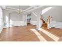 Bright living room featuring hardwood floors, stylish trim, and a coffered ceiling at 720 Goldenrod Way, Norcross, GA 30093