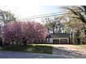 Inviting single-story home with a two-car garage and a beautiful blooming tree in the front at 184 Brandywine Dr, Douglasville, GA 30134